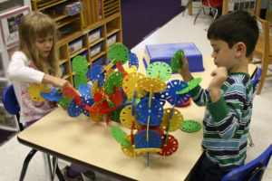 Picture od two kindergarten children building with toys